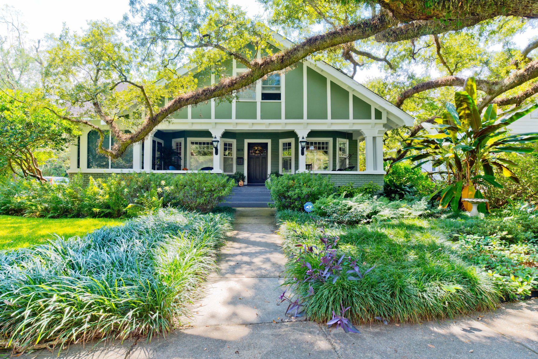 A historic bungalow beneath live oaks in Old Dauphin Way
